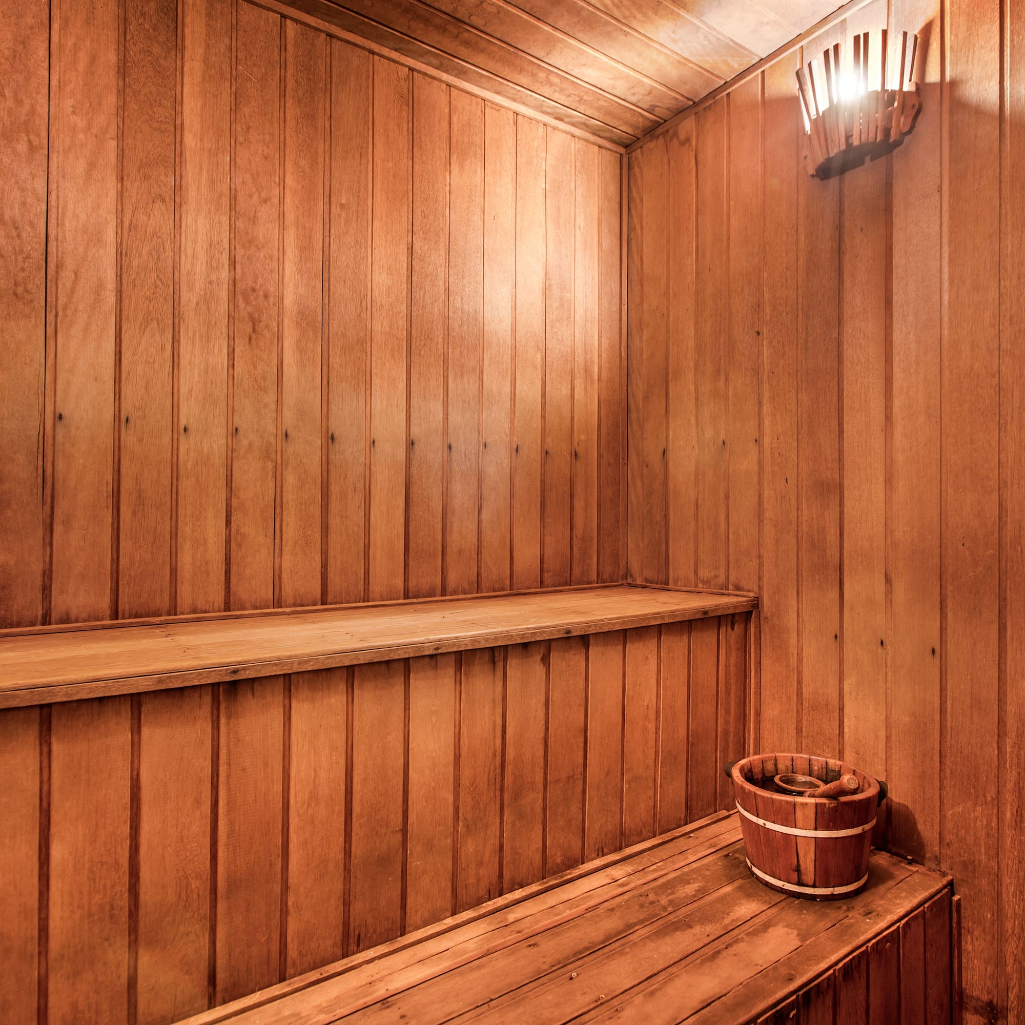 a wooden sauna with a bucket and bucket on a bench
