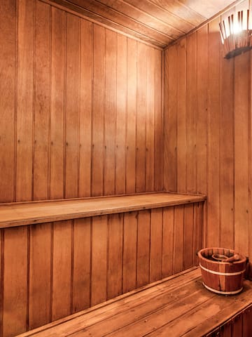 a wooden sauna with a bucket and bucket on a bench
