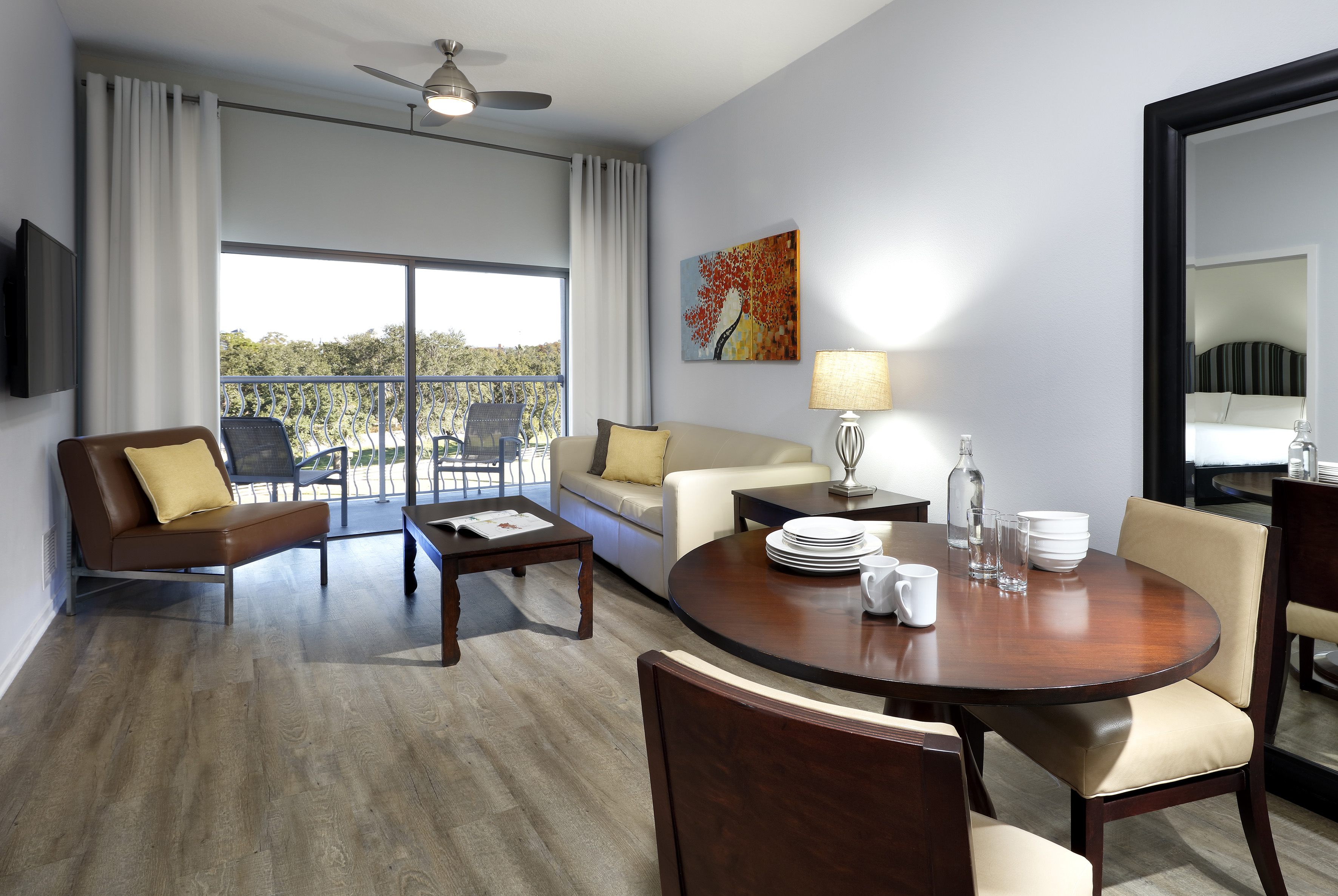 Open concept living-dining room with balcony view, wood floor, modern decor. - One-Bedroom Suite King-Size Bed - Meliá Orlando Celebration, Orlando