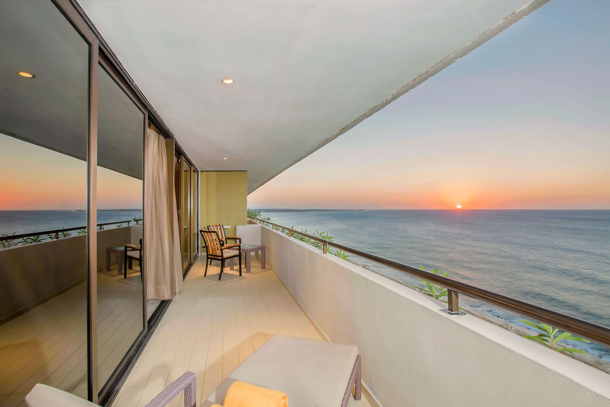 a balcony with chairs and a view of the ocean