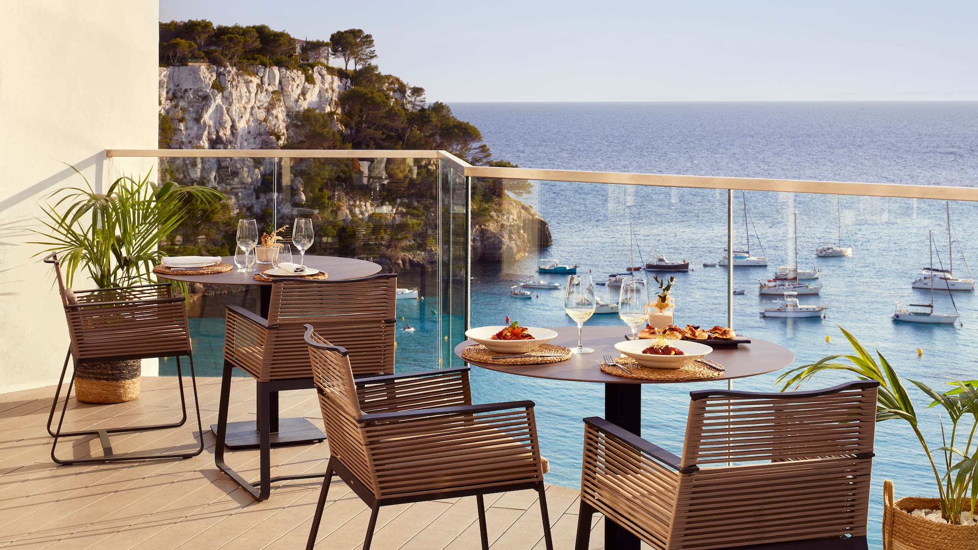 a table and chairs on a deck overlooking a body of water
