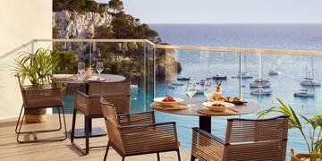 a table and chairs on a deck overlooking a body of water