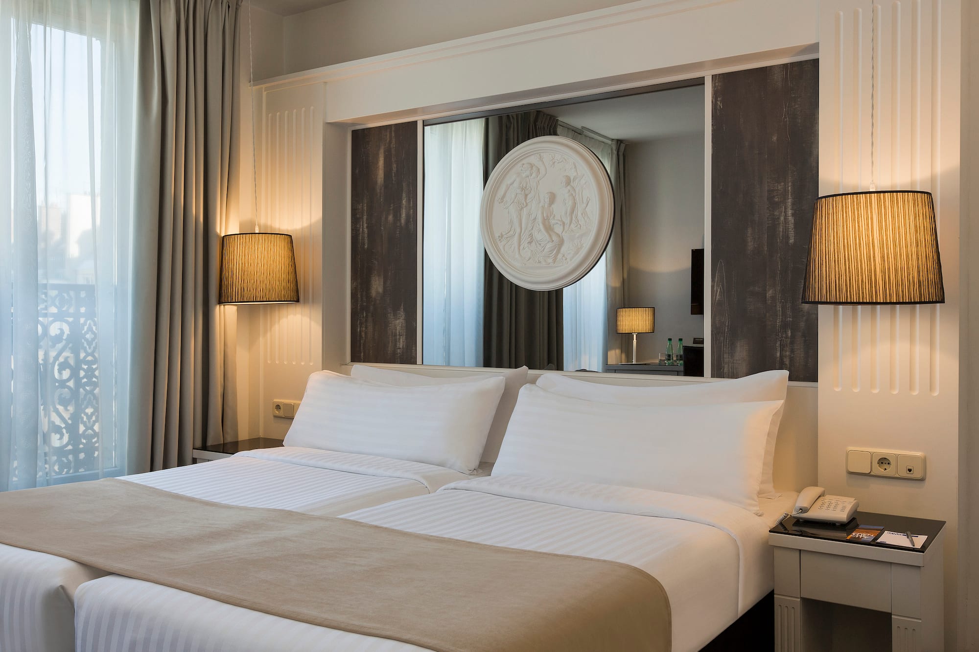 a bed with white sheets and a mirror above it