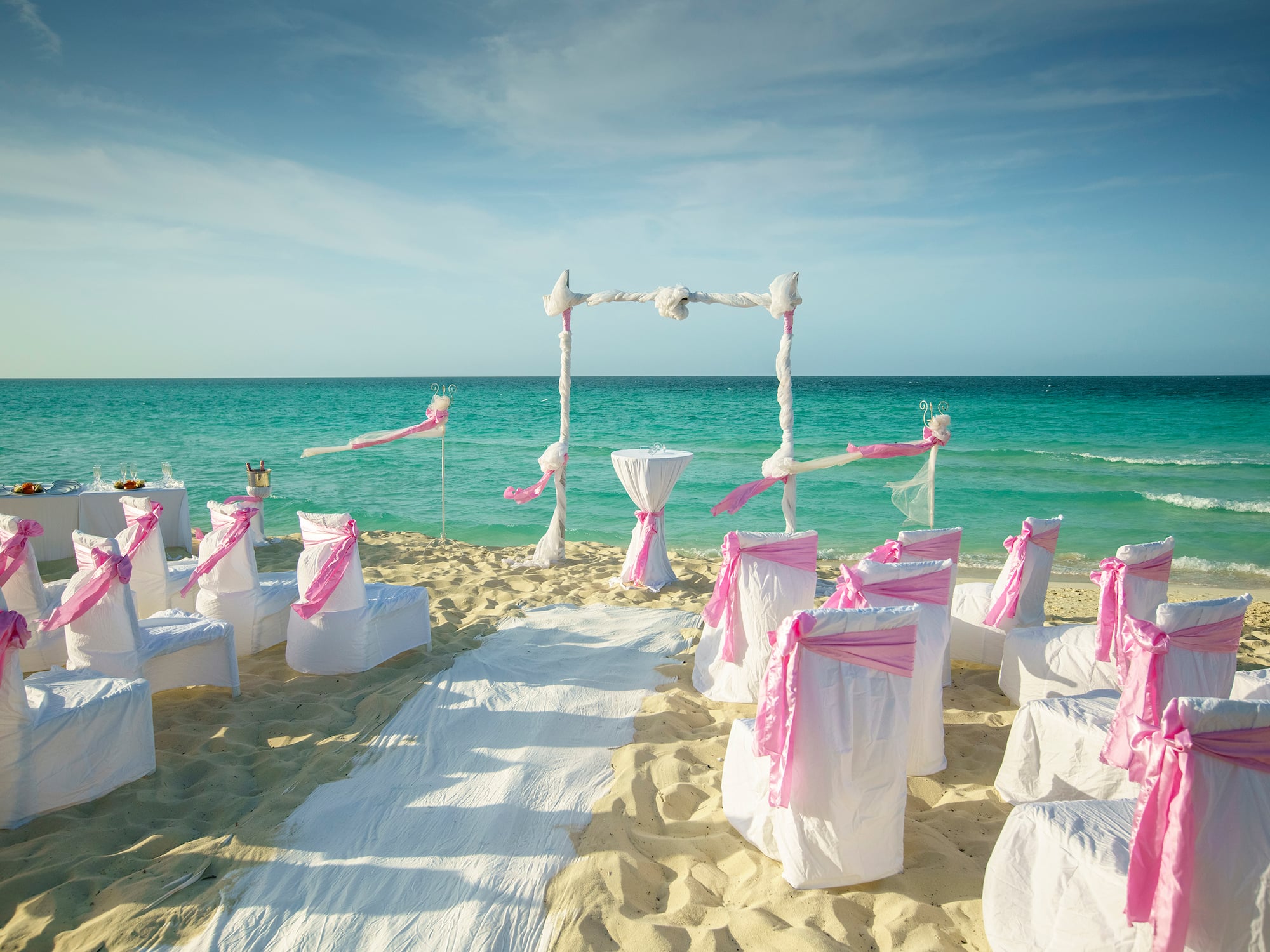 a beach setting with chairs and pink ribbons