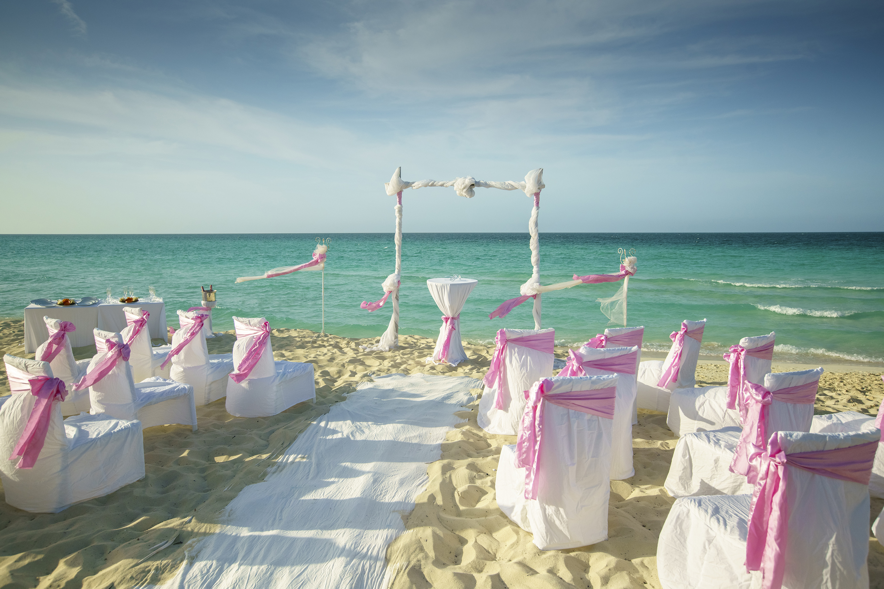 a beach setting with chairs and pink ribbons