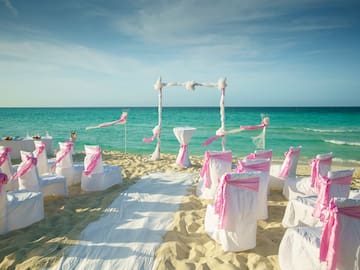 a beach setting with chairs and pink ribbons