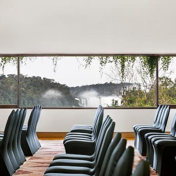 a room with chairs and a view of a waterfall