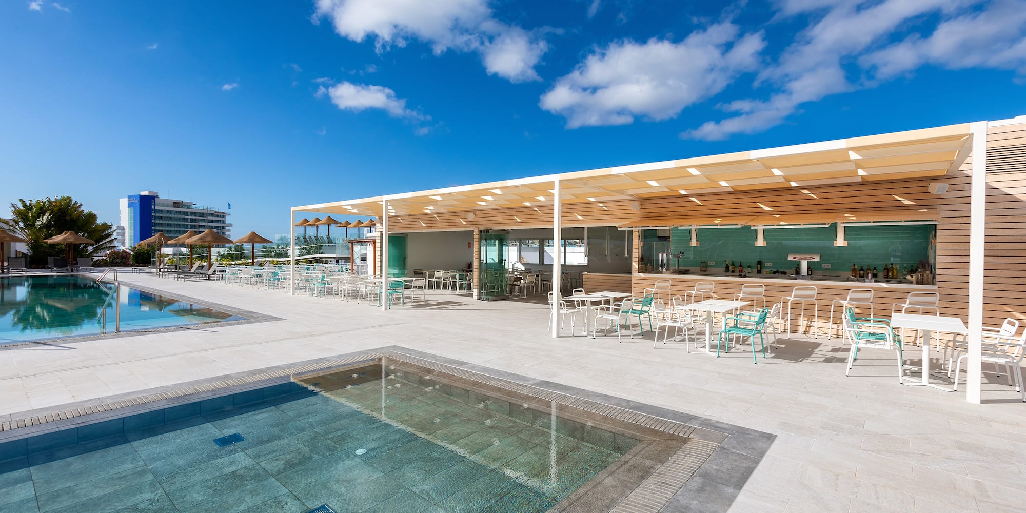 a pool and tables with umbrellas and chairs