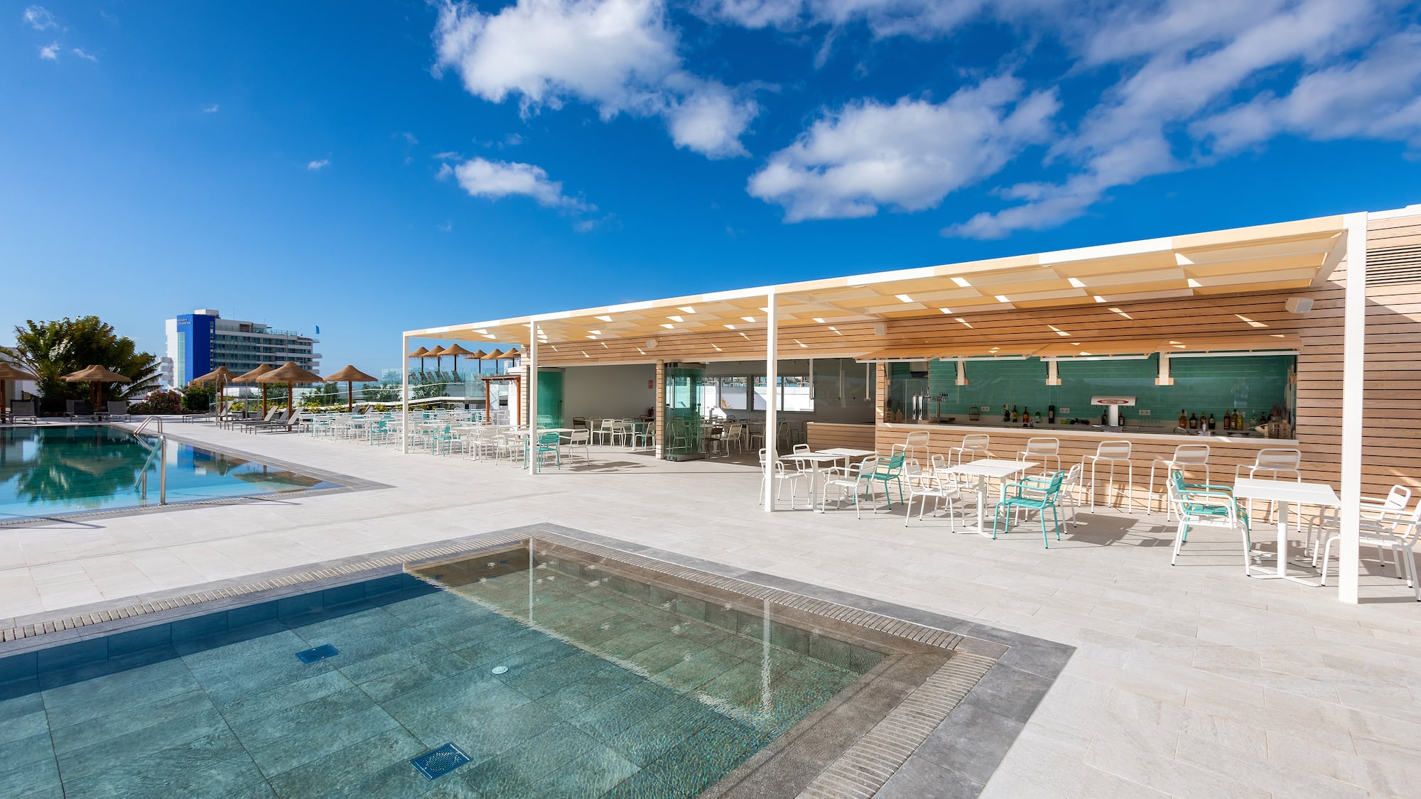 a pool and tables with umbrellas and chairs