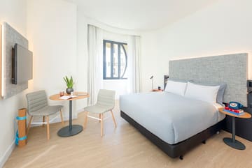 a bedroom with a bed and chairs