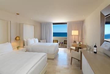 a room with two beds and a table and chairs
