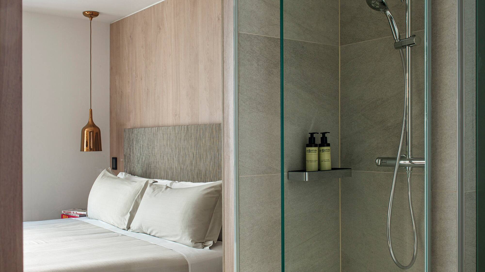 a shower with a bed and a glass door
