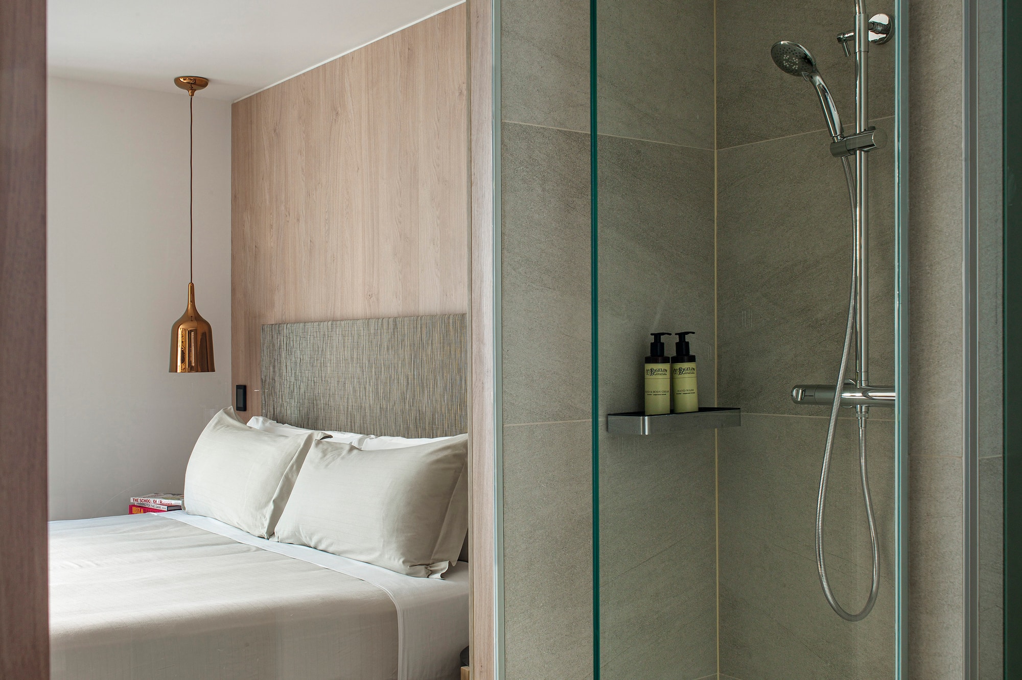 a shower with a bed and a glass door