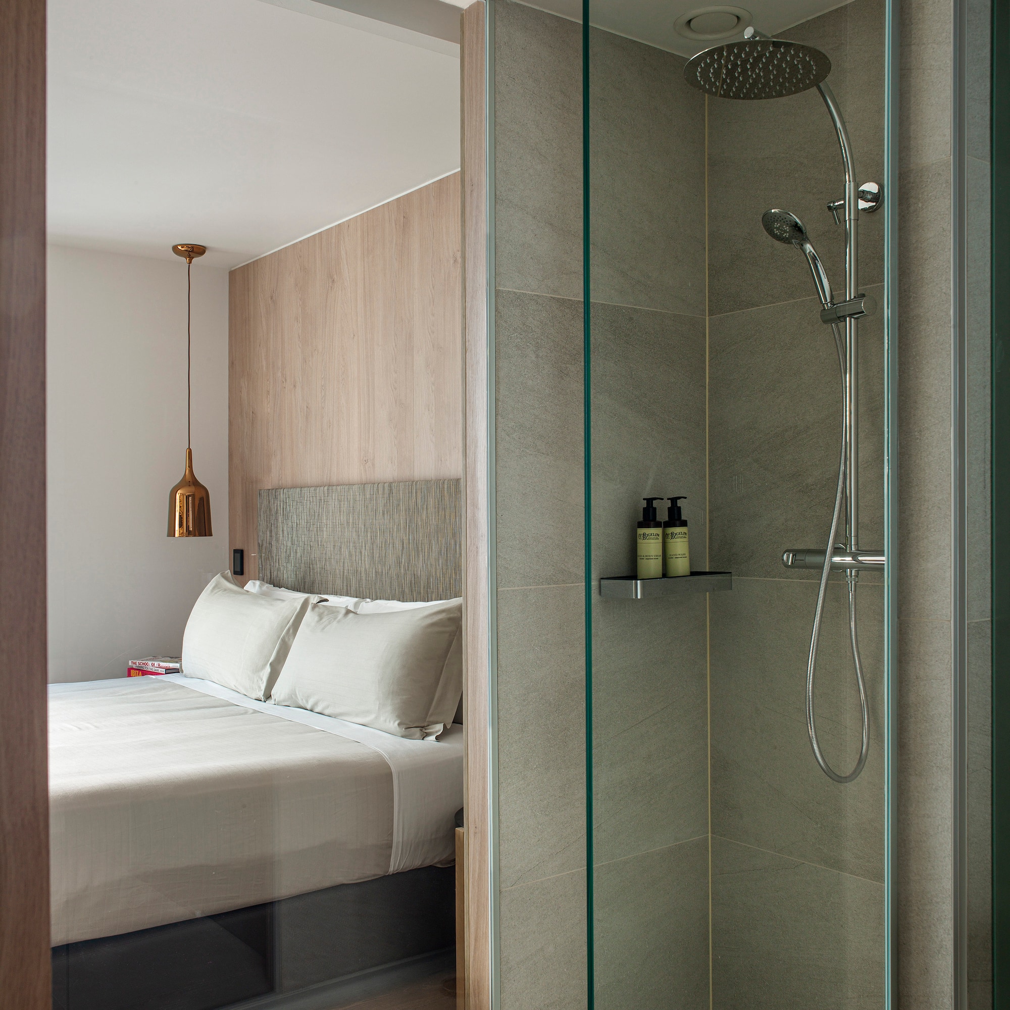 a shower with a bed and a glass door
