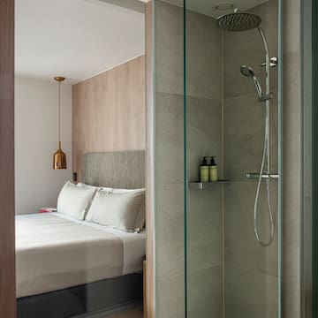 a shower with a bed and a glass door