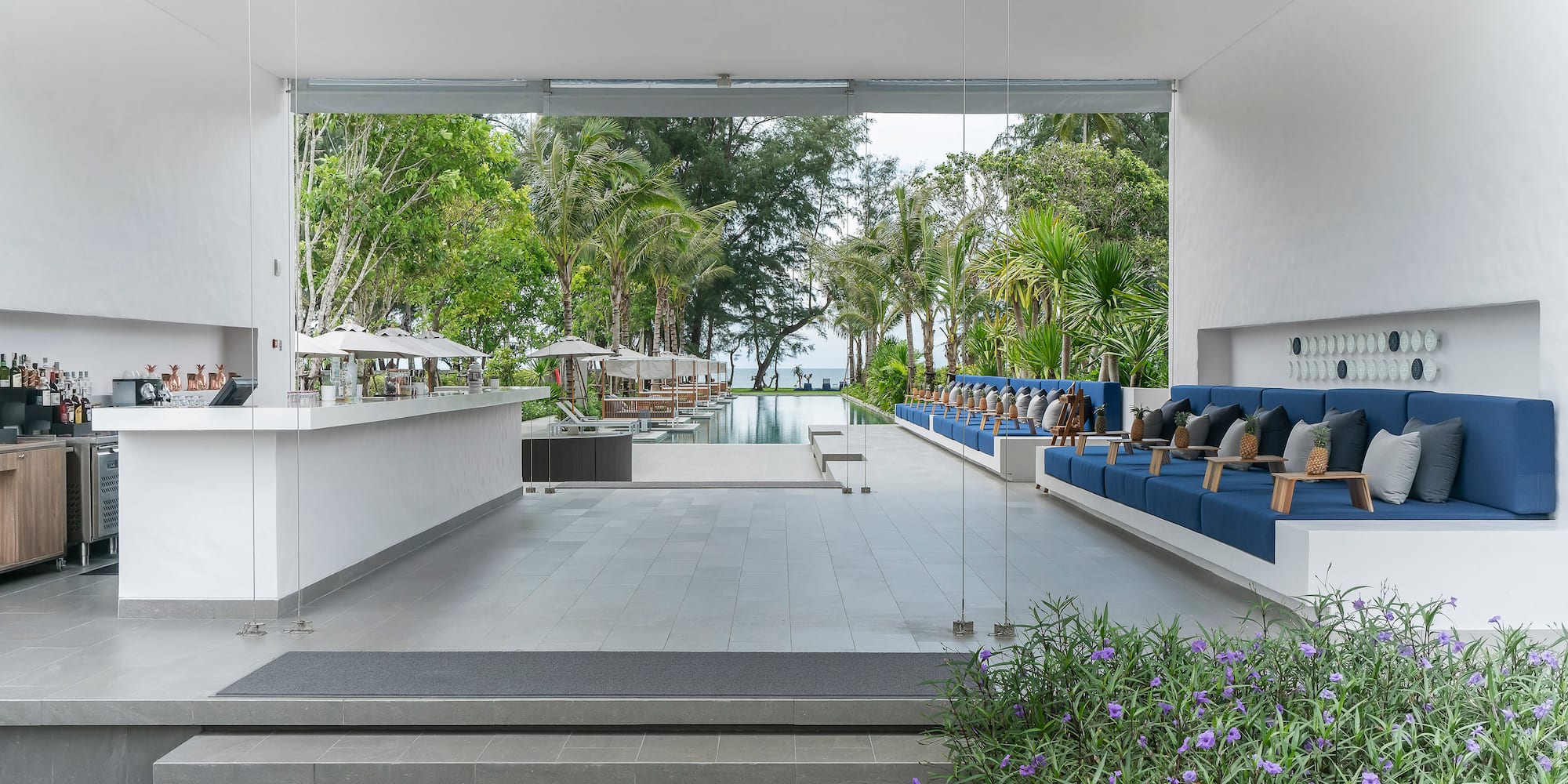 a white building with blue chairs and a pool