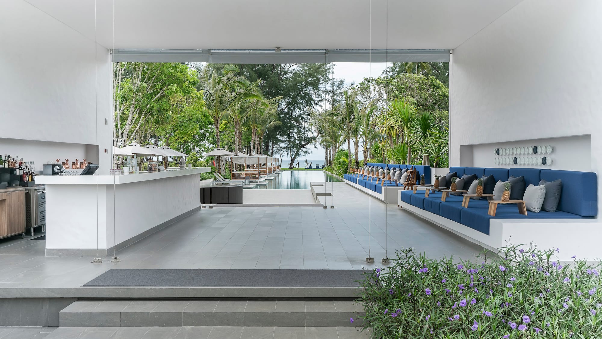 a white building with blue chairs and a pool