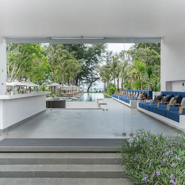 a white building with blue chairs and a pool