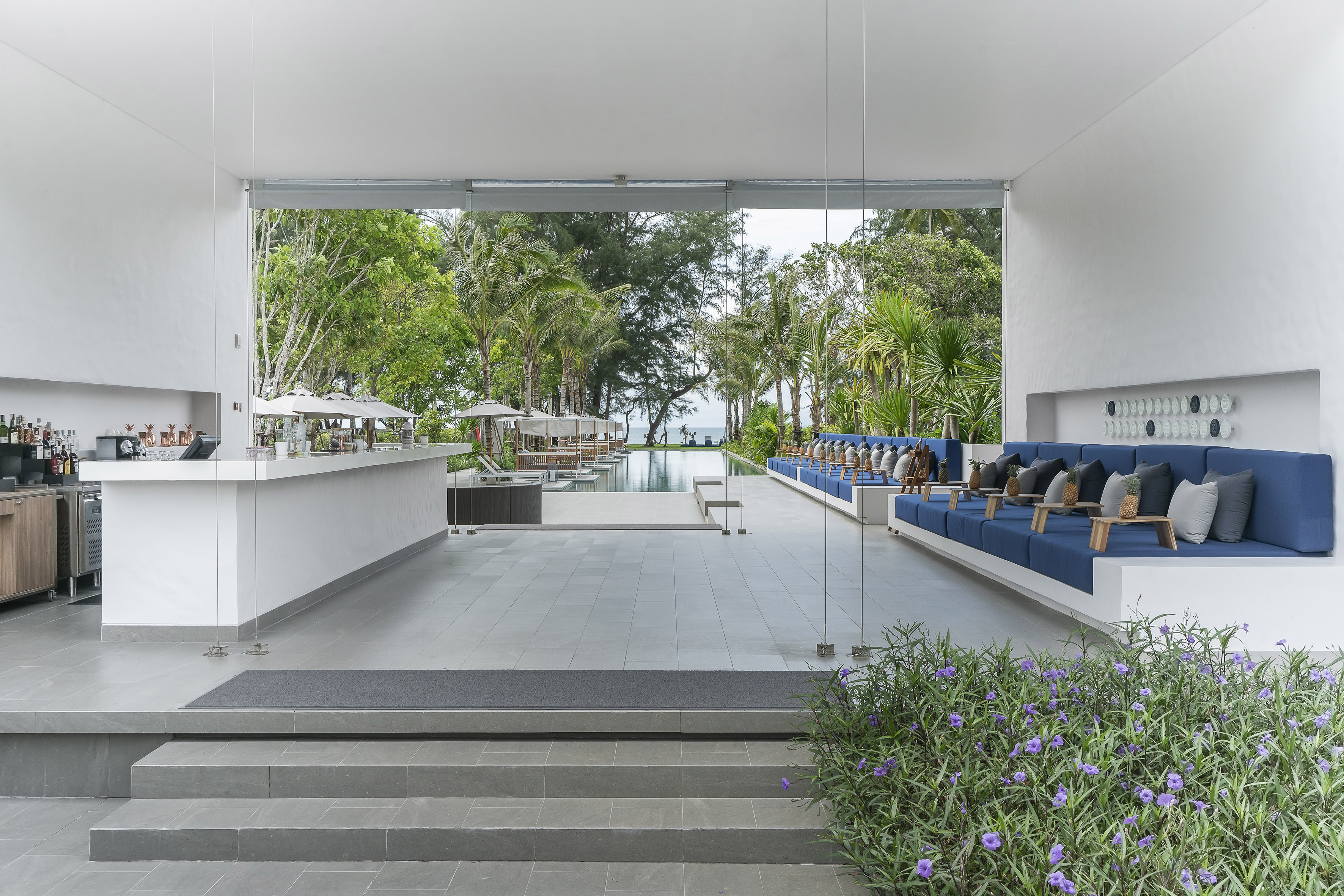 a white building with blue chairs and a pool