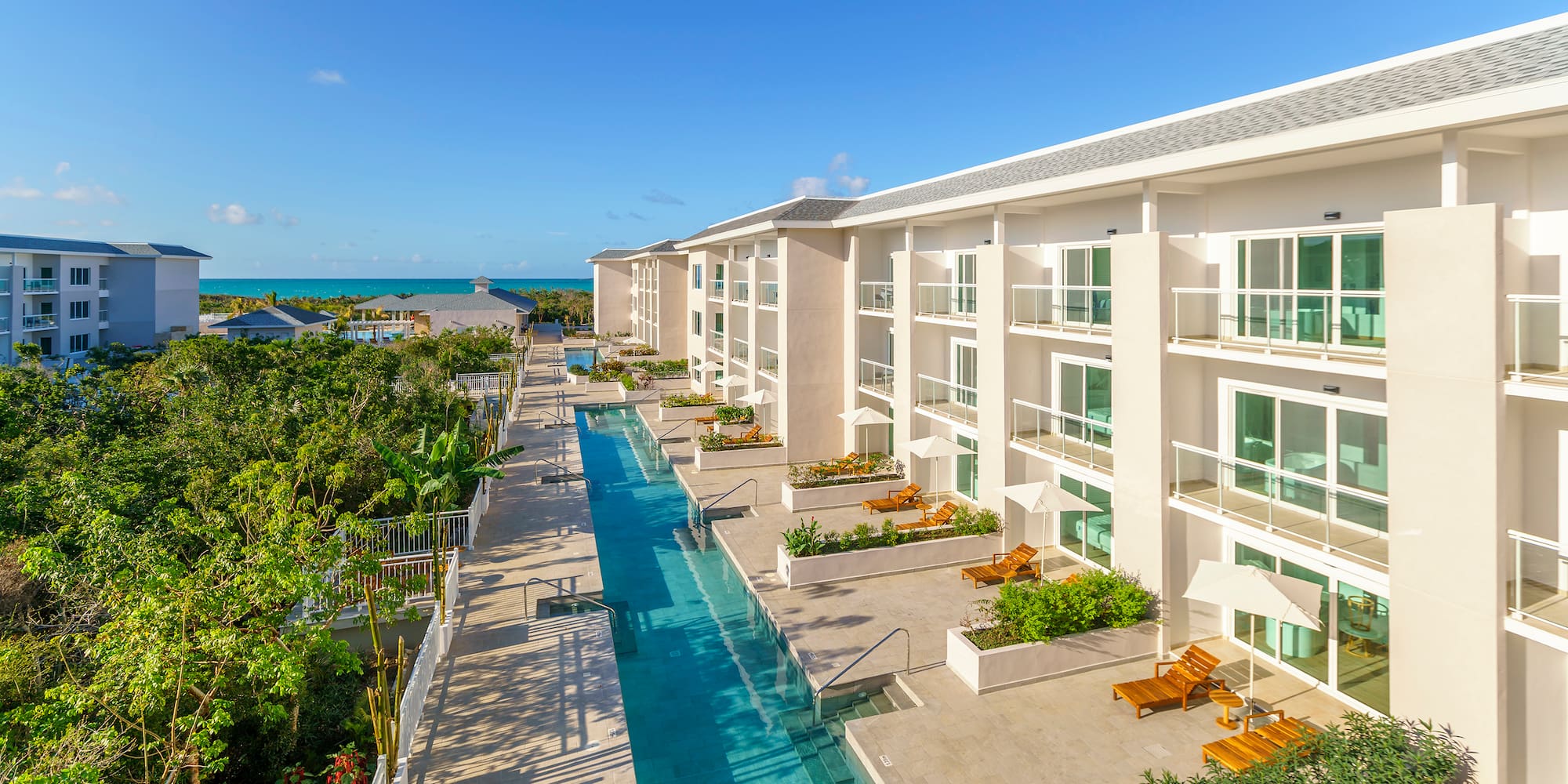a swimming pool with chairs and trees in the background