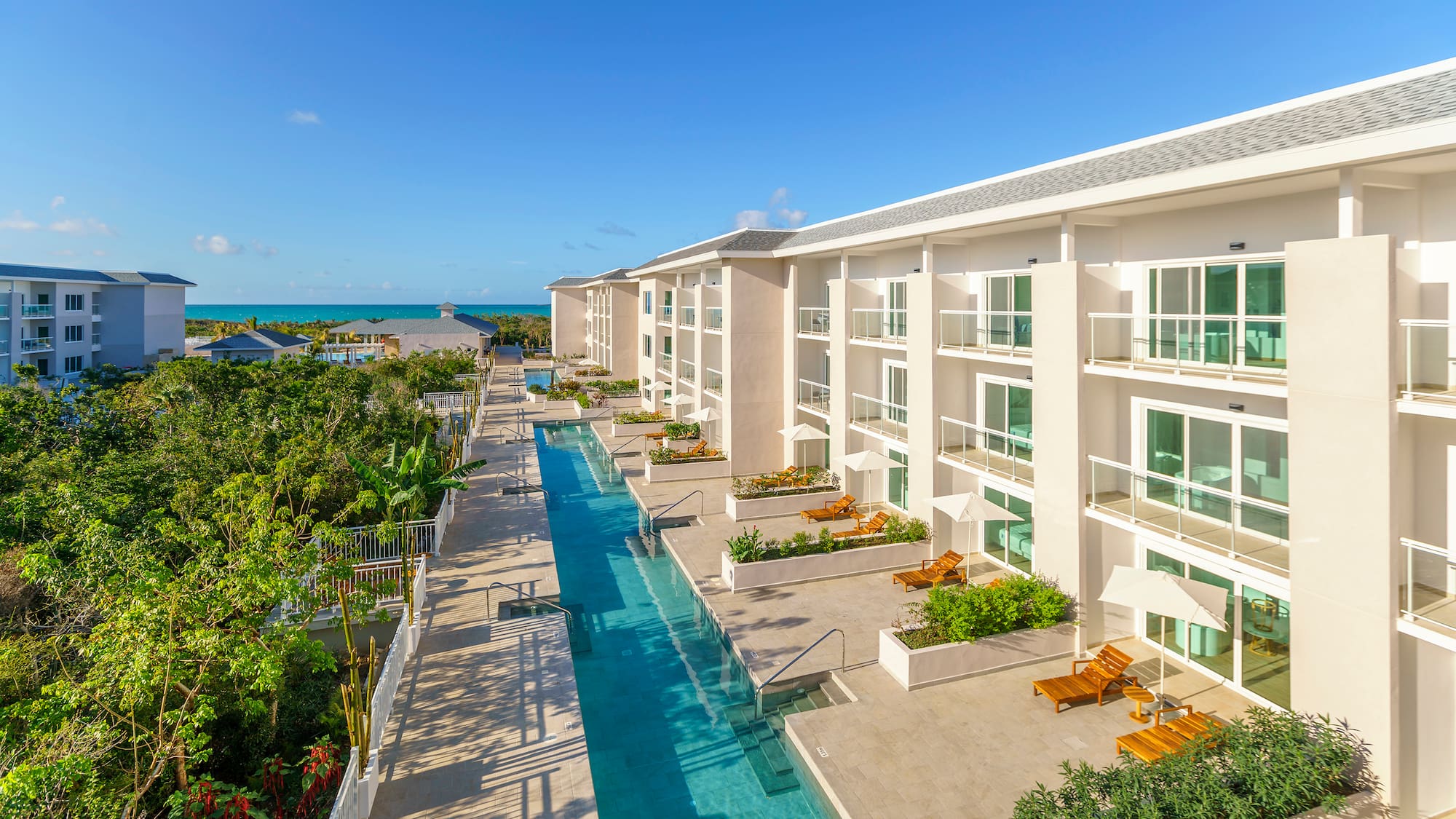 a swimming pool with chairs and trees in the background