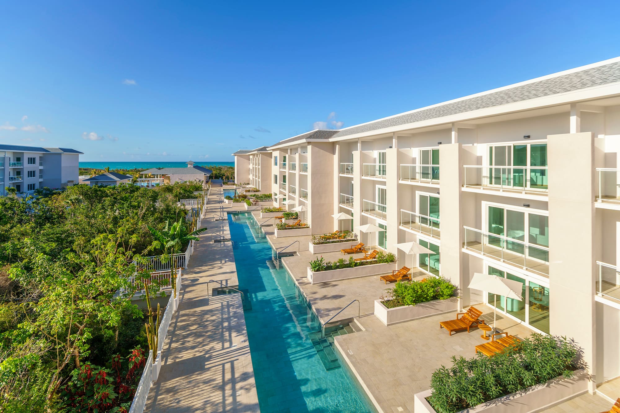 a swimming pool with chairs and trees in the background