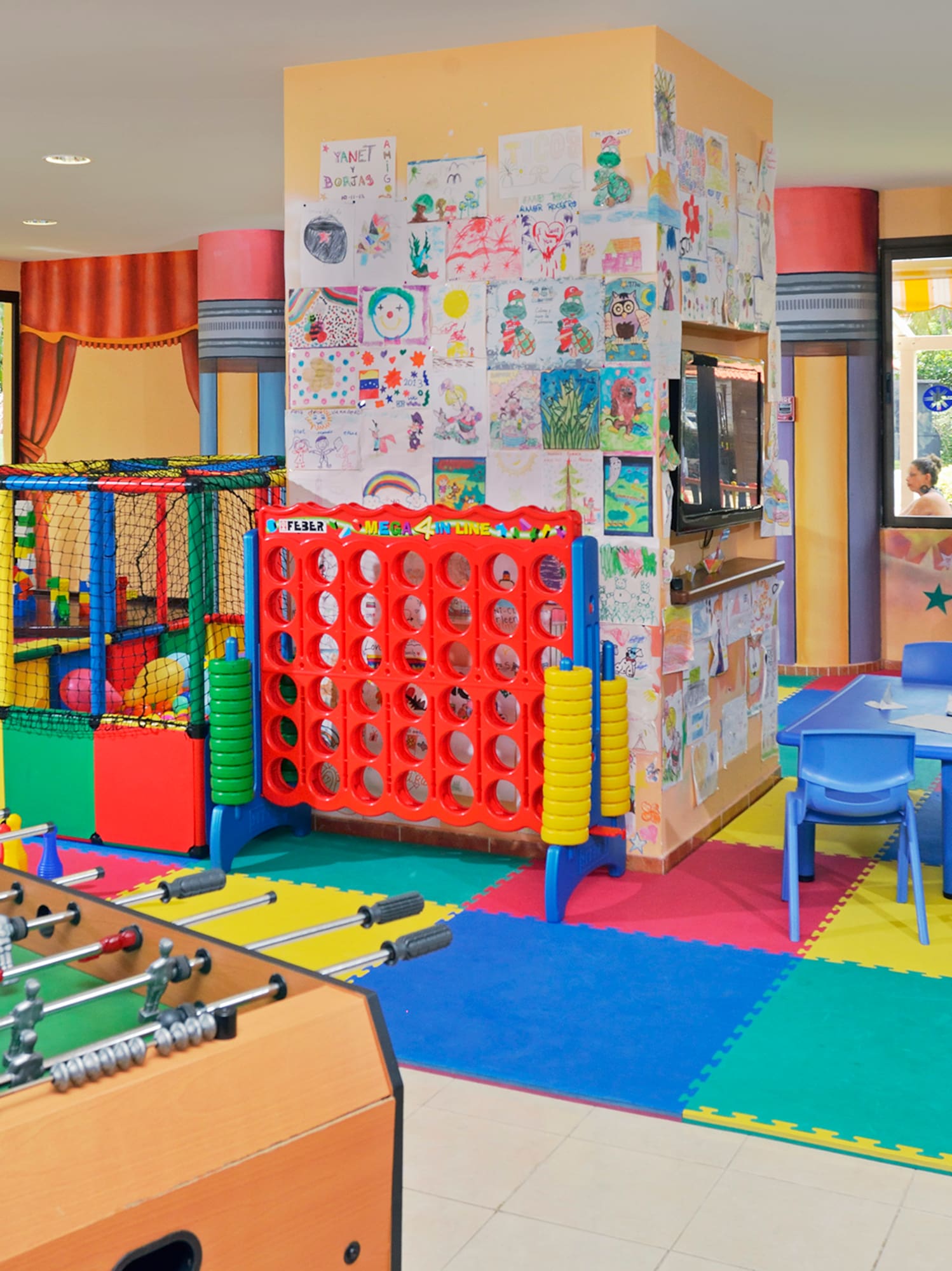a room with a foosball table and a kid playing