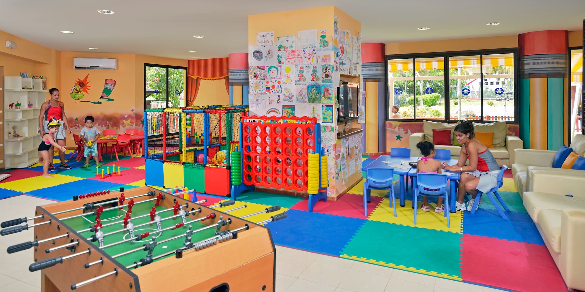 a room with a foosball table and a kid playing