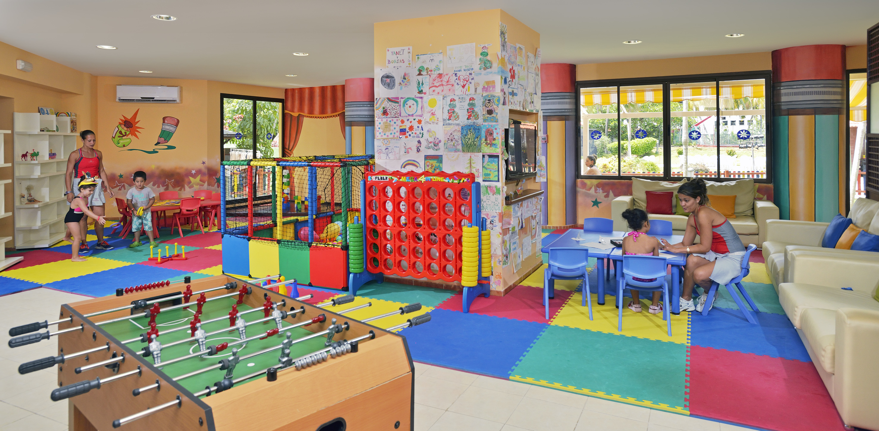 a room with a foosball table and a kid playing