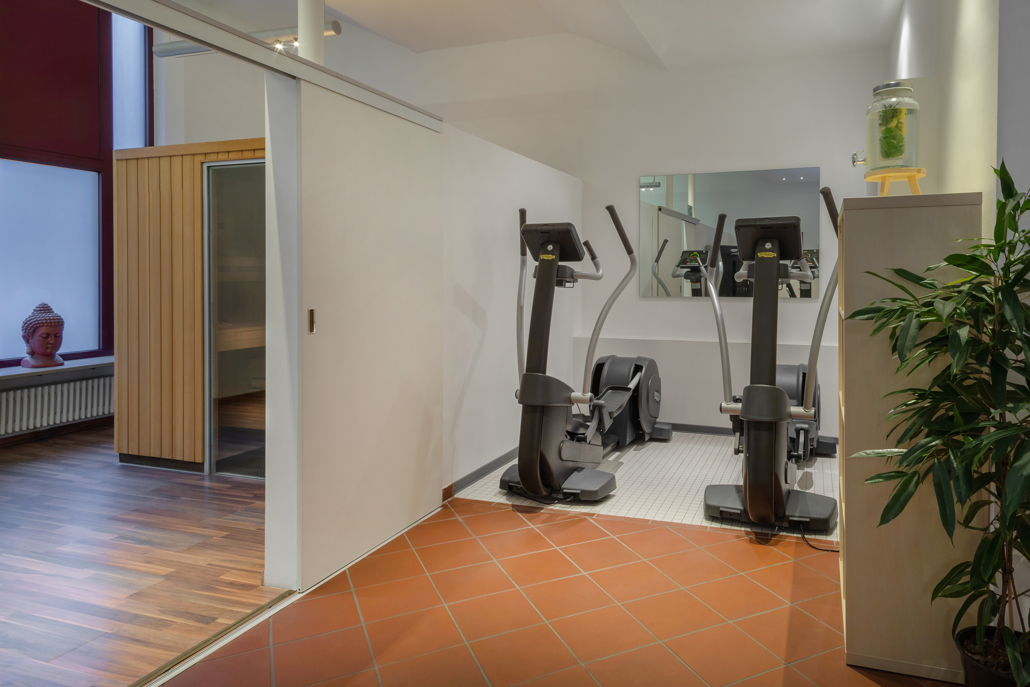 Fitness room featuring ellipticals, sauna, and a refreshing water station.