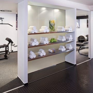 a room with a shelf of towels and exercise equipment