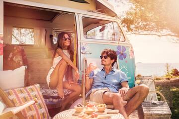 a man and woman sitting in chairs next to a van