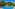 Bright blue swimming pool in a tropical garden with palm trees and distant volcano.