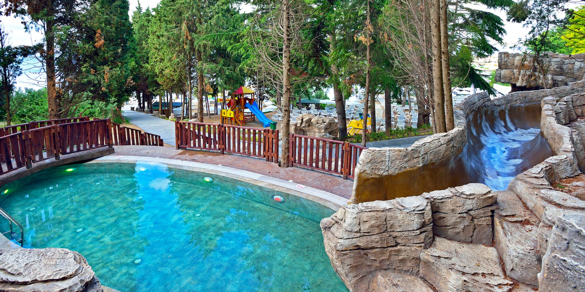 a pool with a slide and trees