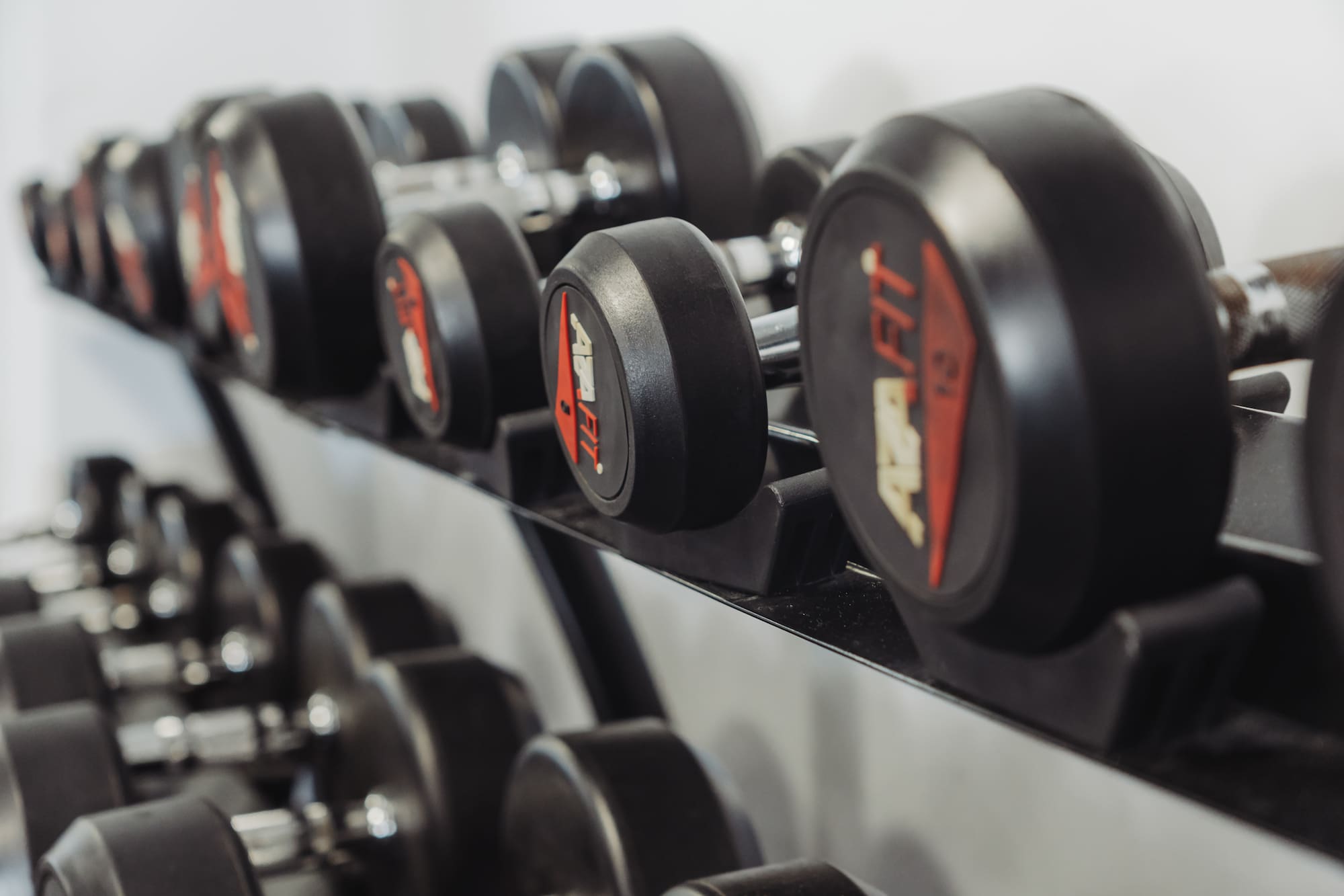 a row of dumbbells on a shelf