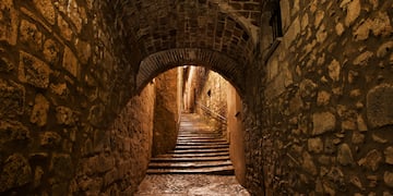 a stone tunnel with stairs and archways
