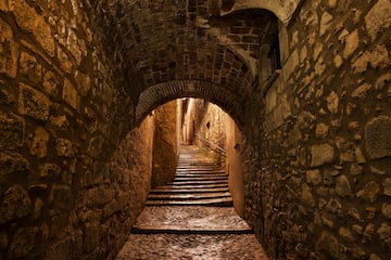 a stone tunnel with stairs and archways