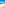 Sunny sandy beach, blue ocean, and promenade with distant coastal city.