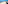 Sunny sandy beach, blue ocean waves, paved promenade, and distant coast.