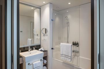 een badkamer met douche en wastafel
