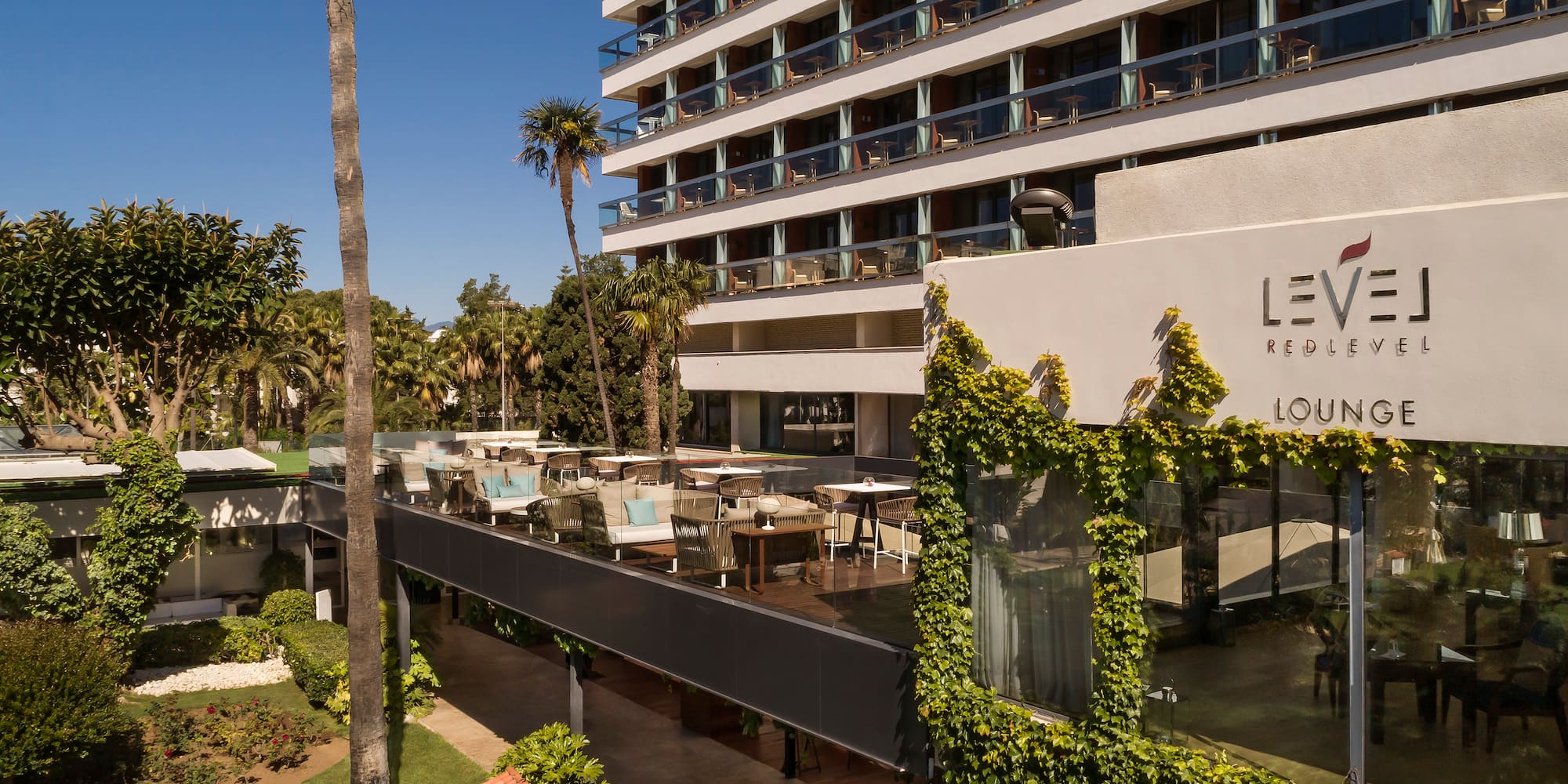 a building with a large white building with trees and plants