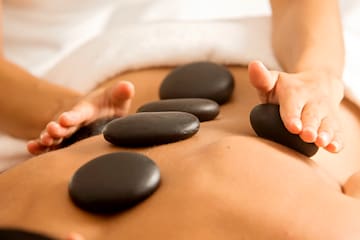 a person getting a hot stone massage
