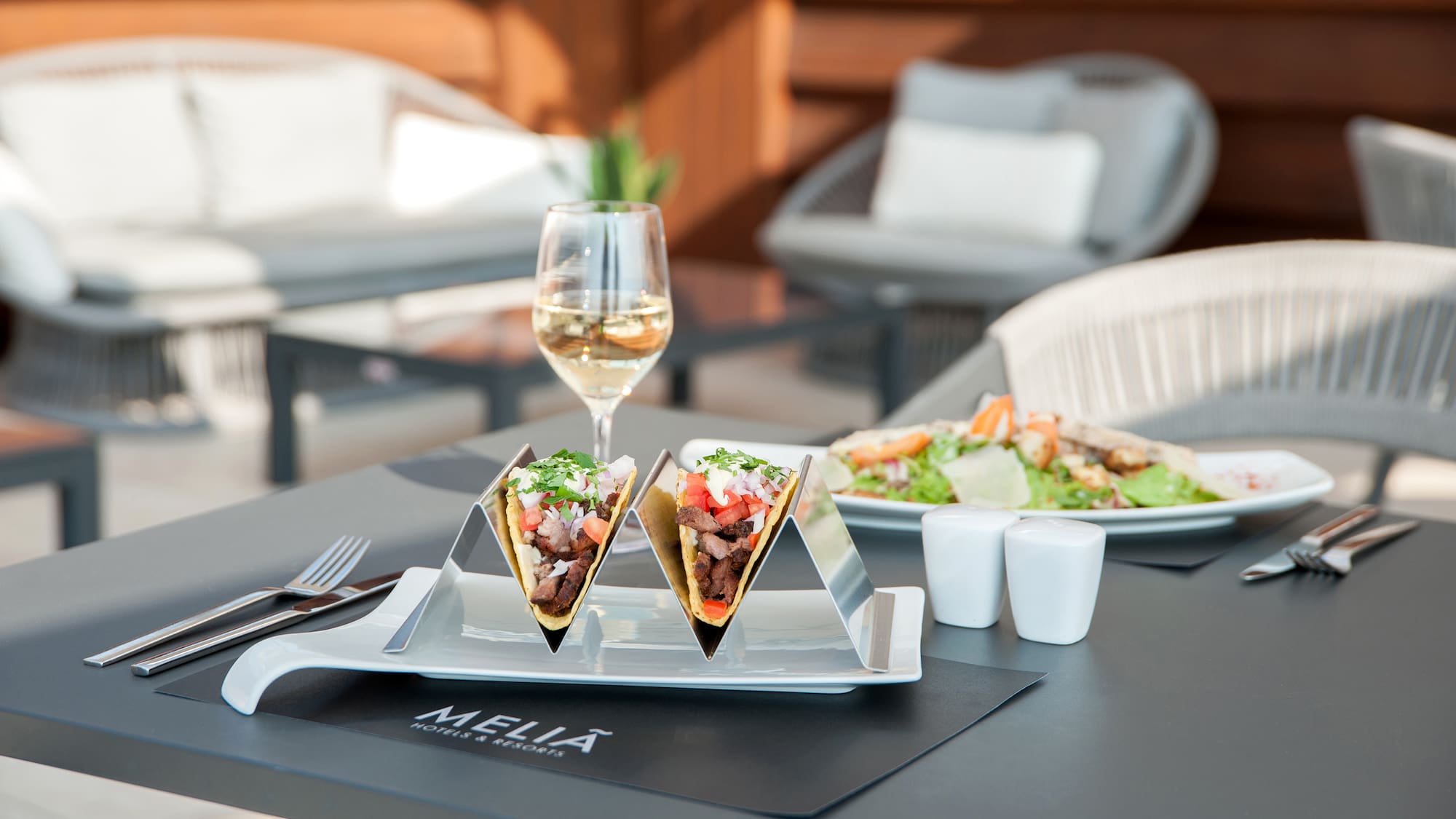 tacos on a plate with a glass of wine on a table