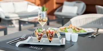 tacos on a plate with a glass of wine on a table
