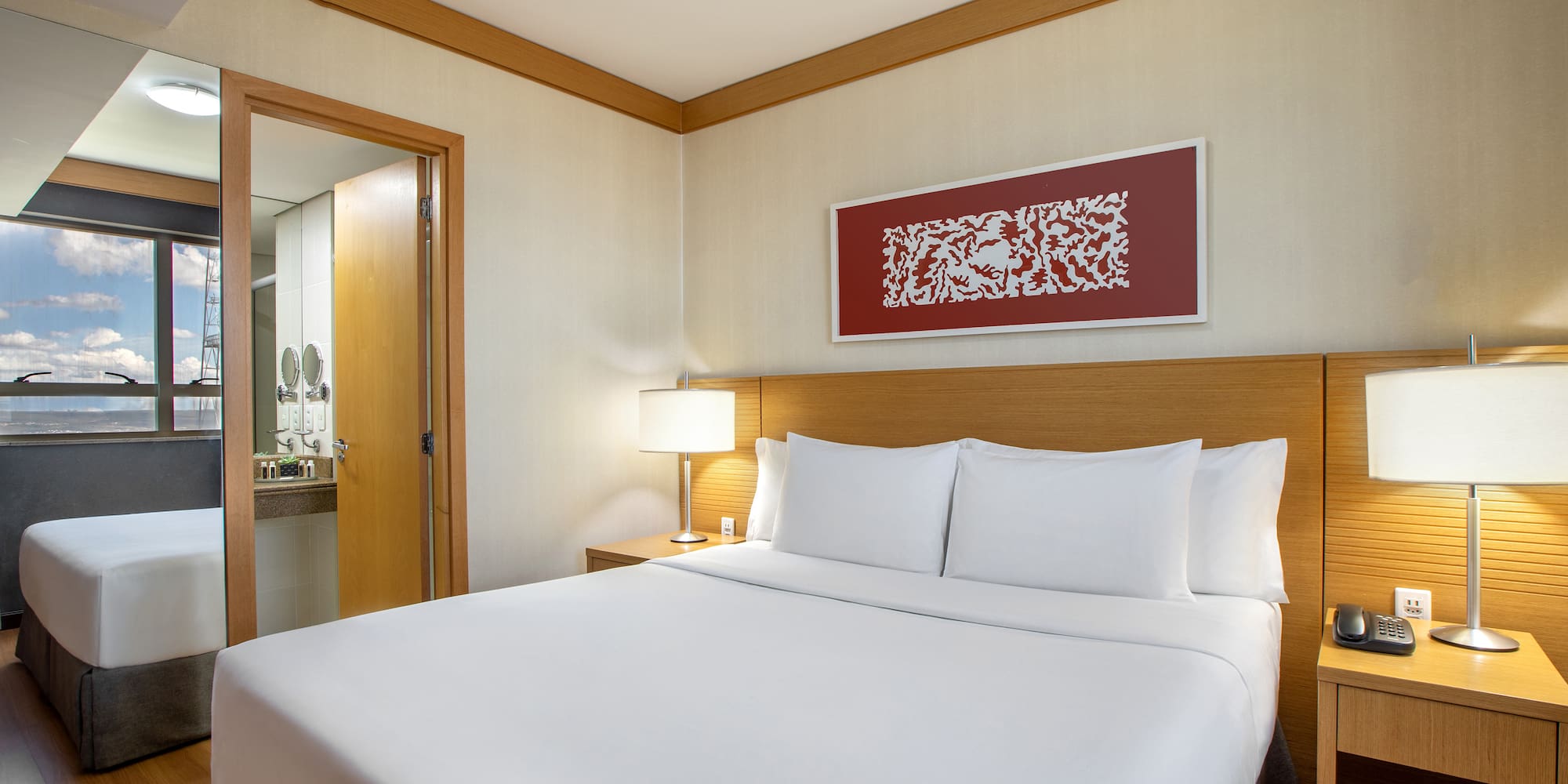 a bed with white sheets and a lamp