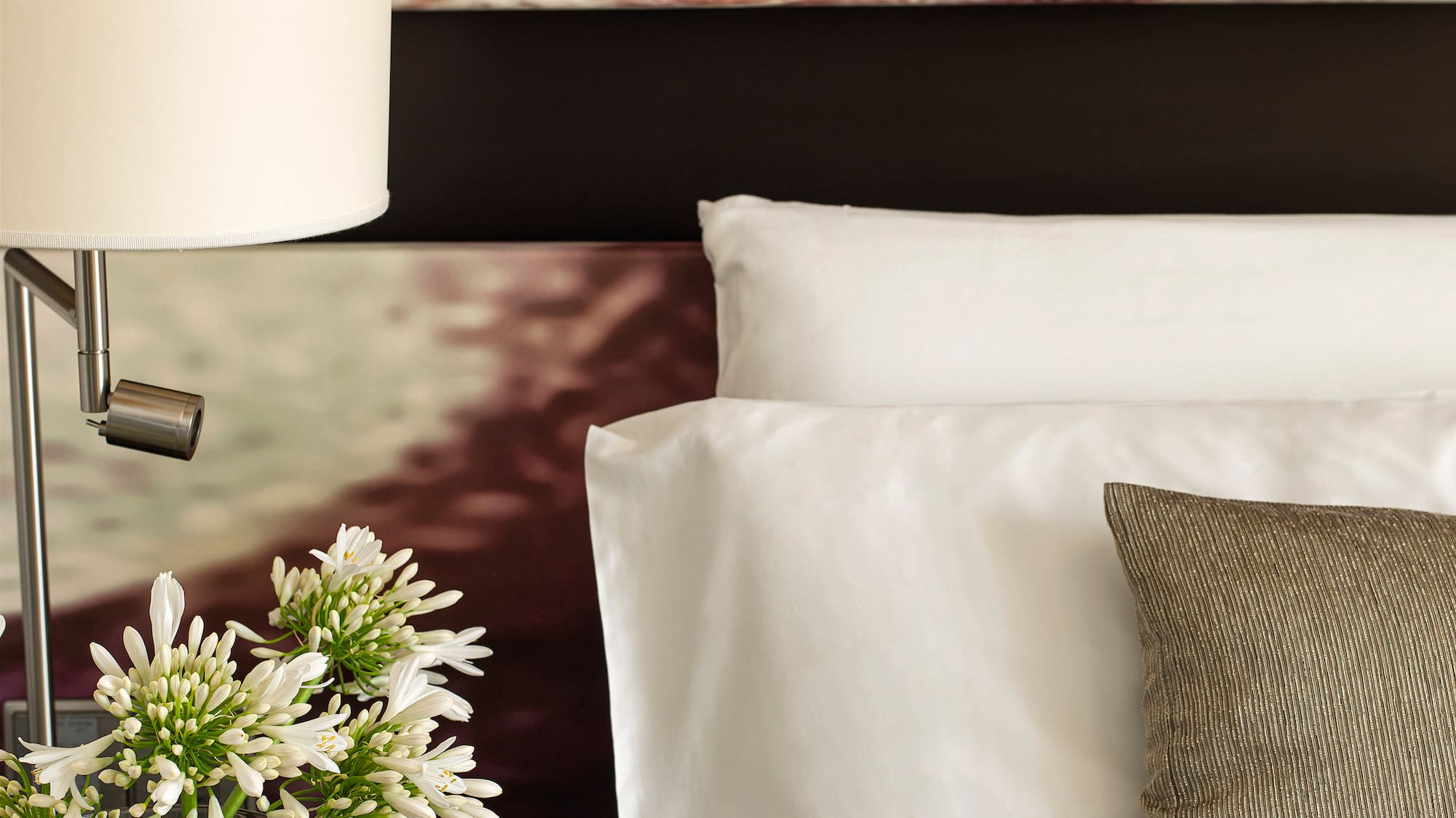 a lamp on a table next to a bed