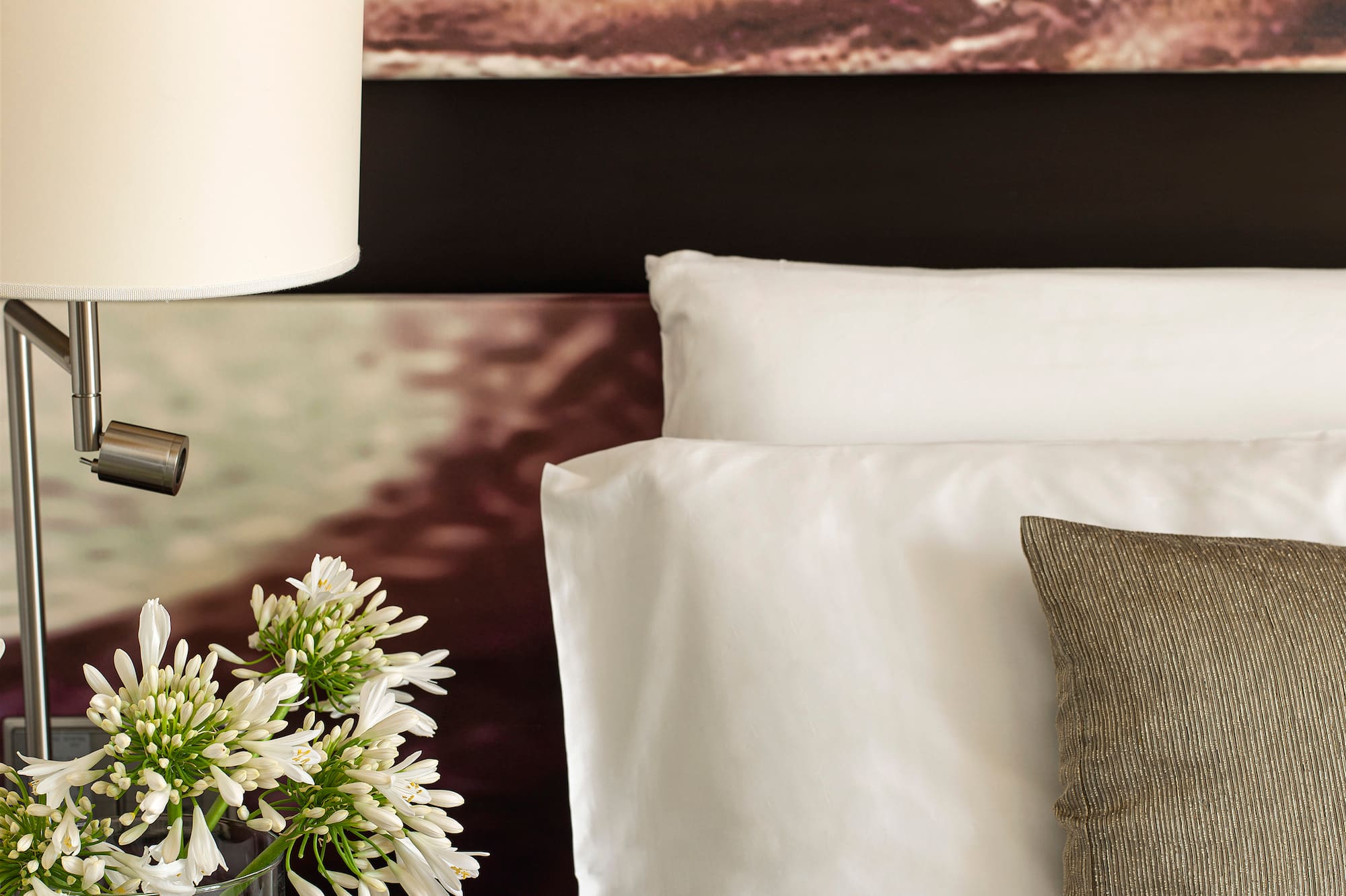 a lamp on a table next to a bed