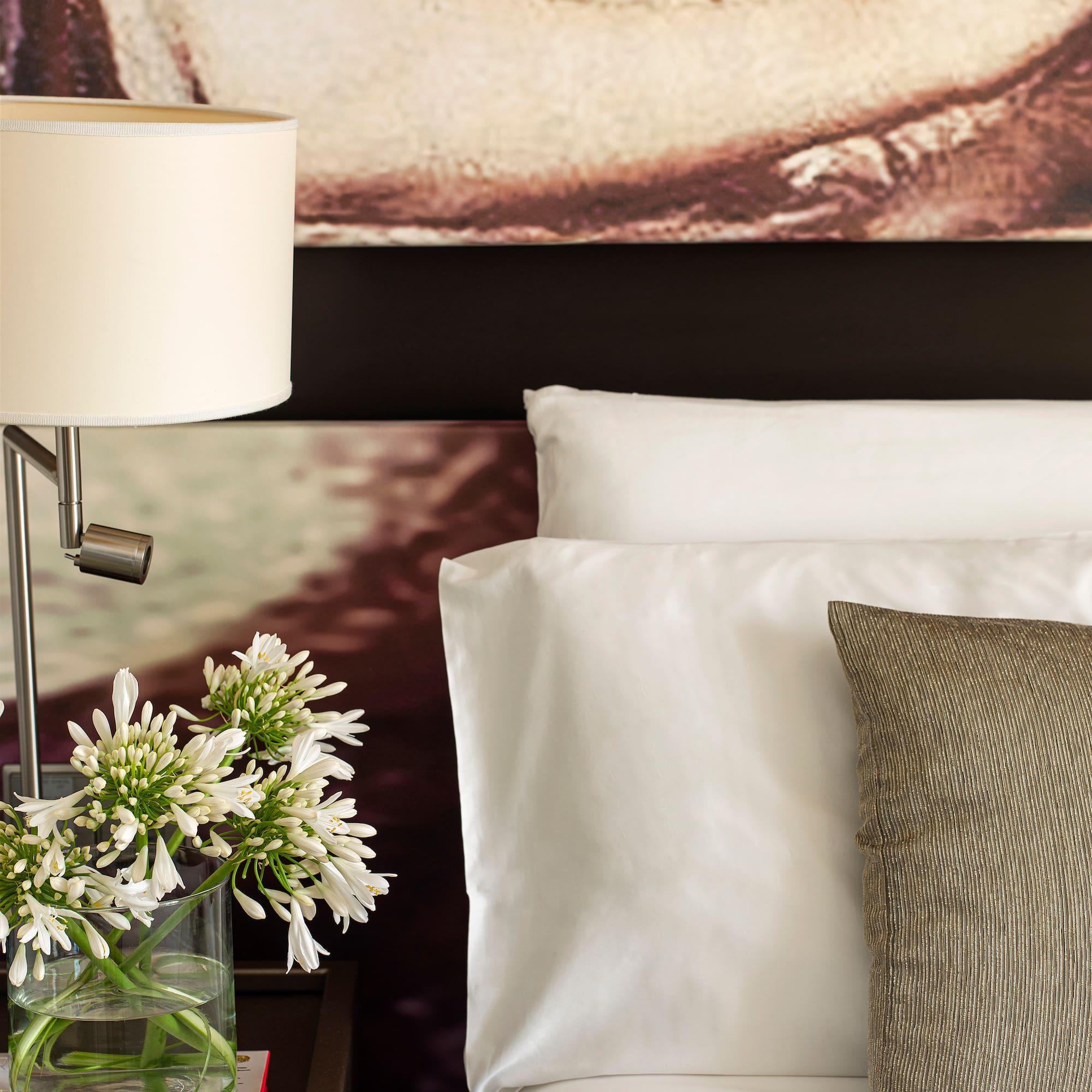 a lamp on a table next to a bed