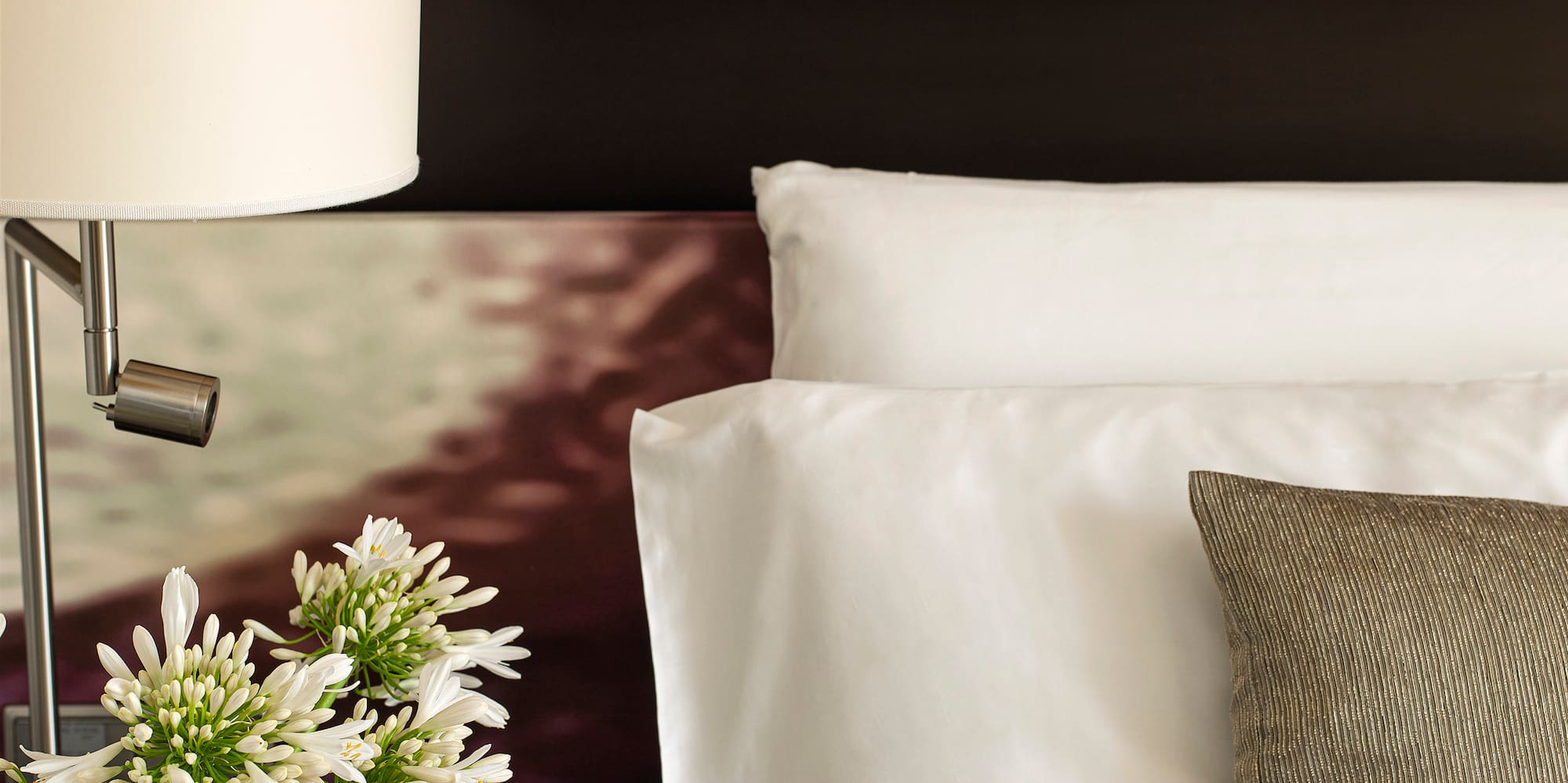 a lamp on a table next to a bed