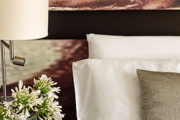 a lamp on a table next to a bed